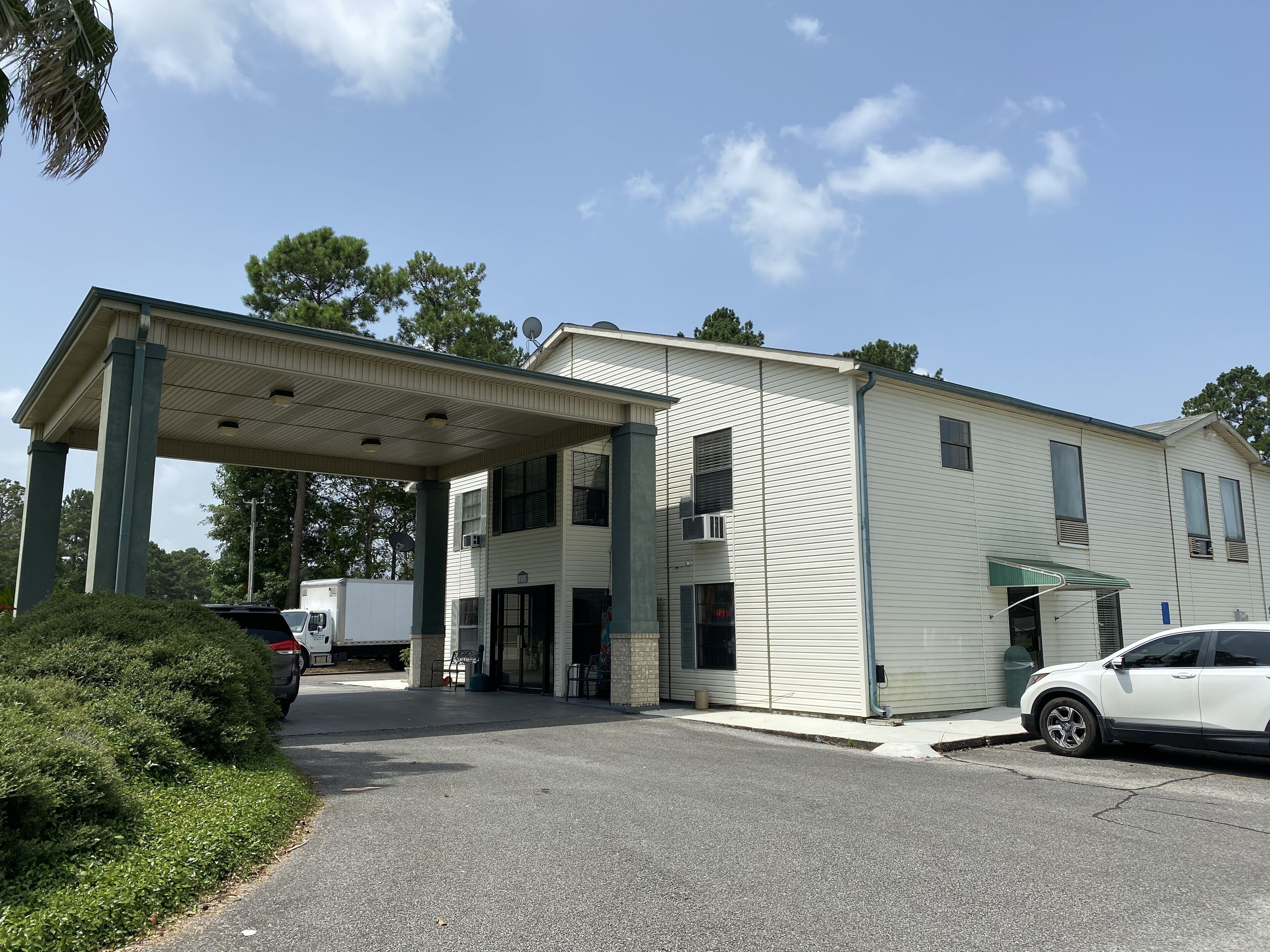 A two-story building with a covered entrance and a small attached structure.