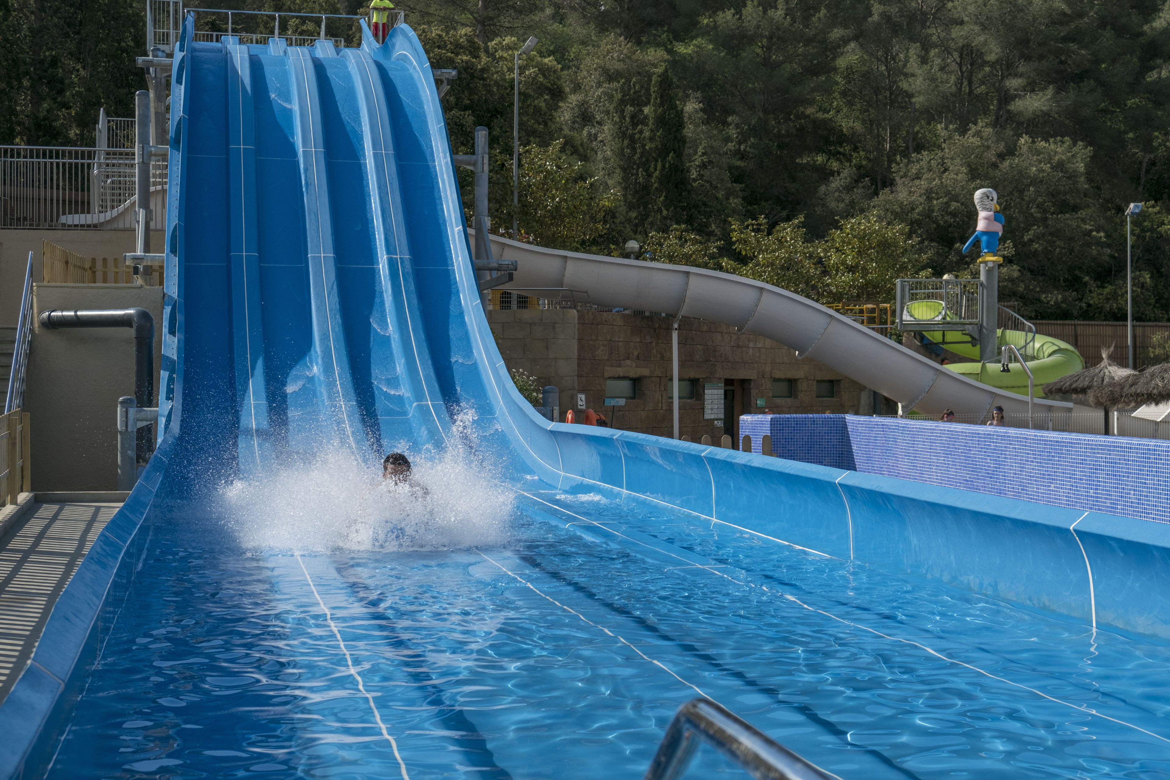 Um tobogã num parque temático com uma piscina na base.
