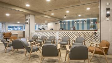 A modern reception area with a counter, seating, and a view of the outdoors.