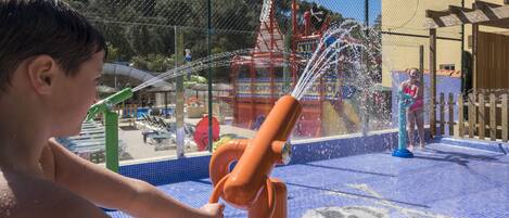Un área de juegos acuáticos con piscina, toboganes y una estructura temática pirata.