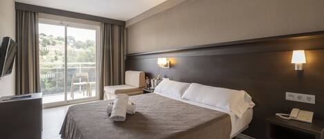 A hotel room with a bed, a desk, a chair, a TV, and a balcony with curtains.