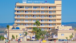 Un hôtel appelé Casablanca, doté de nombreux balcons, situé en bord de mer et bordé de palmiers.