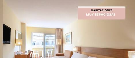 Amplia habitación de hotel con dos camas, un escritorio y una silla.