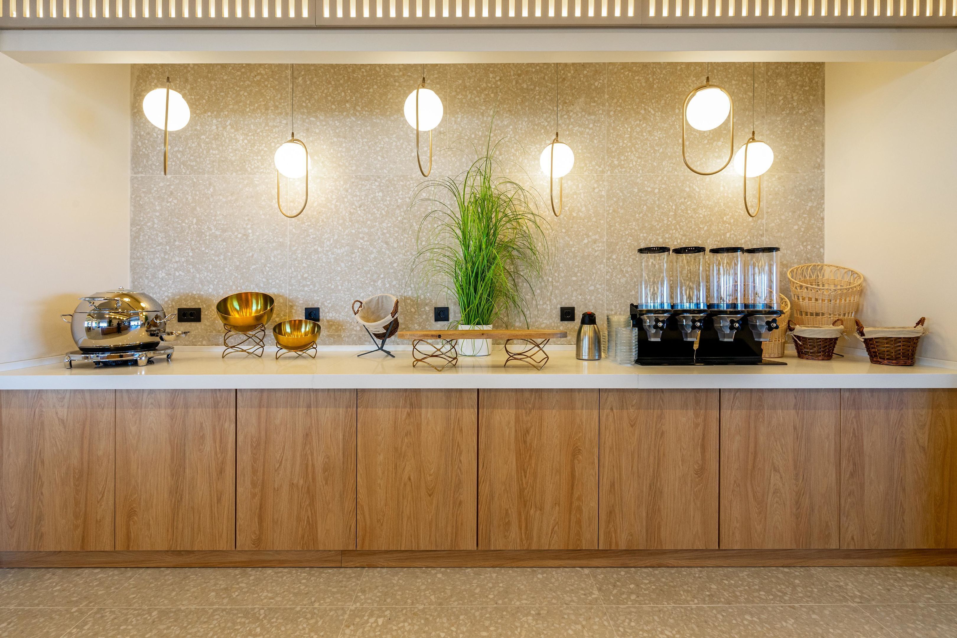 A modern kitchen counter with a coffee machine, bowls, and a potted plant.