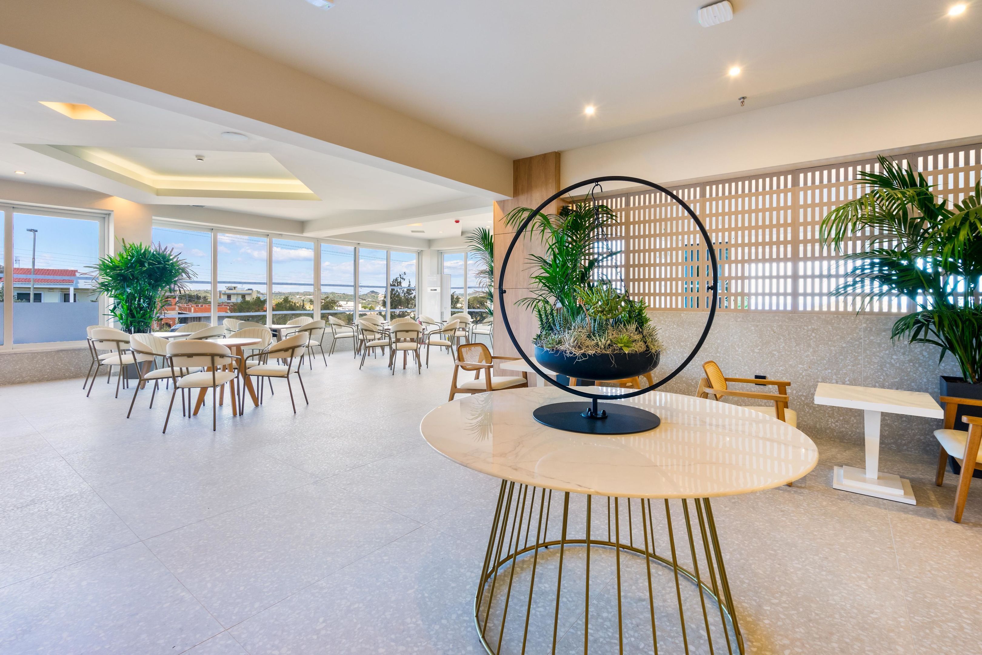 A spacious indoor area with multiple tables and chairs, a decorative globe centerpiece, and large windows offering views of the outside.