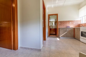 Une cuisine avec des meubles de rangement en bois, un plan de travail et une fenêtre.