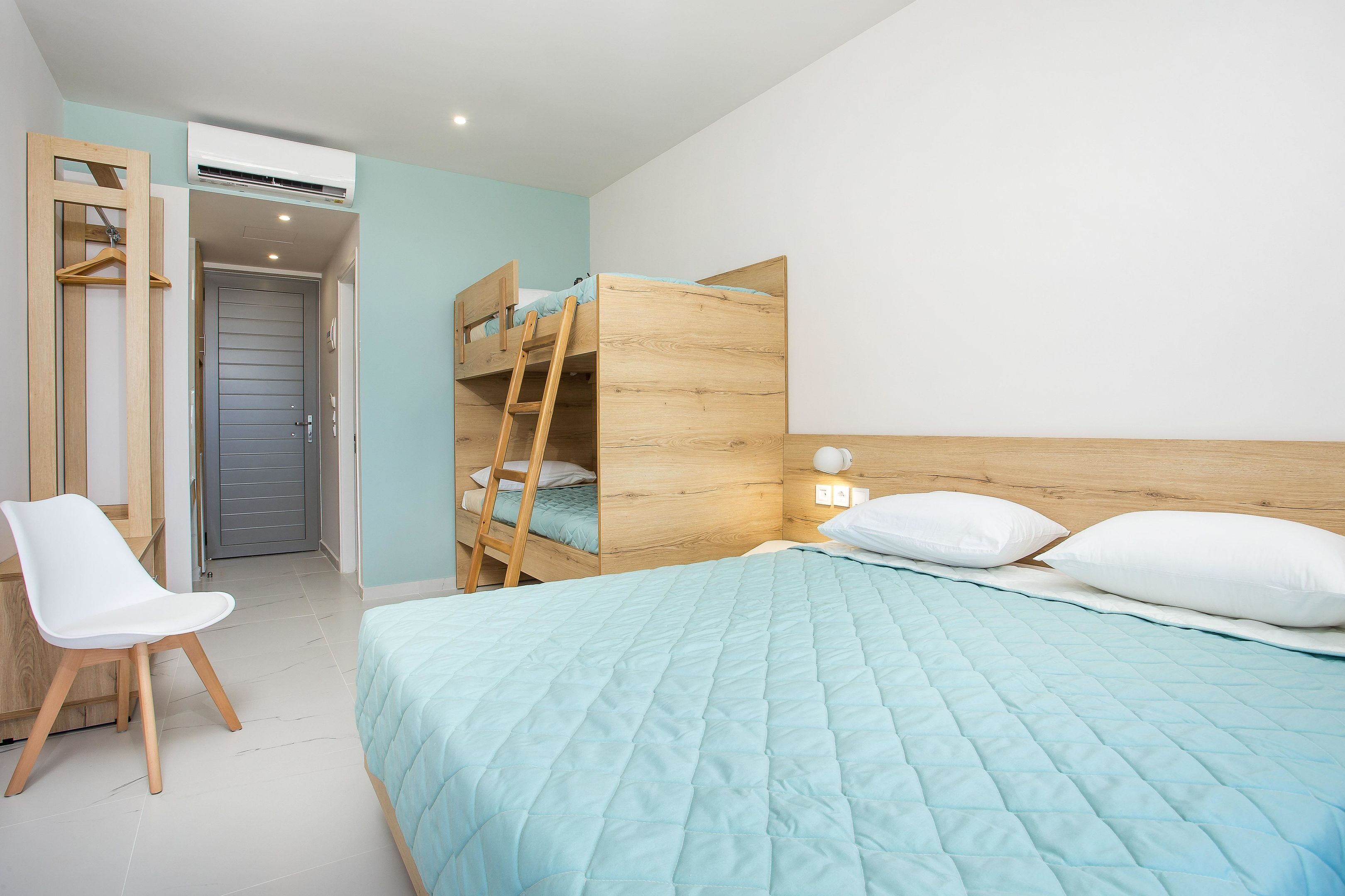 A bedroom with a bunk bed, a desk, and a chair.