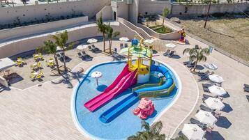 A water park with slides, a pool, and lounge areas with umbrellas.