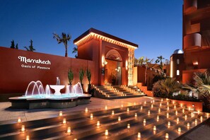 A hotel entrance with a fountain, steps adorned with candles, and a sign reading "Marrakech Oasis of Pleasure." - Venezia Resort Hotel & Spa - All inclusive (Rhodes)