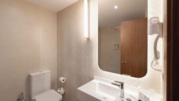 Een moderne badkamer met toilet, wastafel en spiegel.
