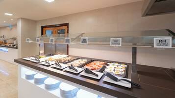Zona de bufé con diversas opciones de comida y un cartel que indica que es solo para adultos.