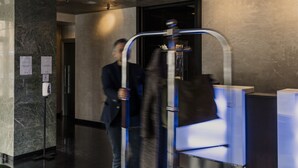 A modern hotel lobby with a reception desk, a seating area, and a staircase. - Hotel Cosmopolitan (Florence)