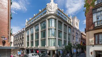 Un edificio histórico con amplias ventanas y detalles arquitectónicos ornamentados.