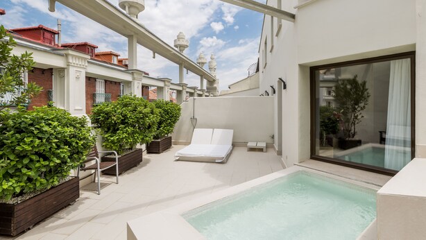 A rooftop terrace with a pool, lounge chairs, and potted plants. - Room Mate Alicia, Madrid (Madrid)
