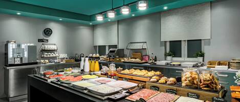 A buffet with various food items and a coffee machine.