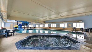 An indoor swimming pool with a slide, seating area, and a hot tub. - Staybridge Suites Calgary Airport by IHG (Calgary)