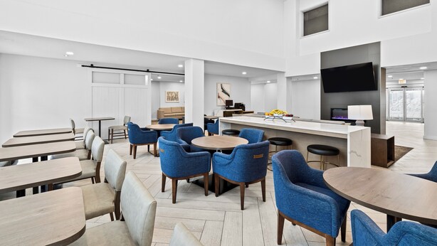 Et moderne interiør med spiseplads, køkken og bar/loungesektion.