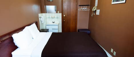 Un dormitorio con cama, cómoda, espejo y puerta.