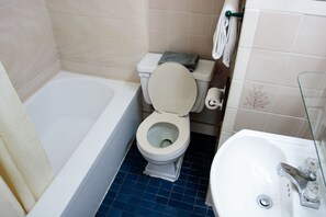 A bathroom with a bathtub, toilet, and sink. - Casa Bella Hotel (Montreal)