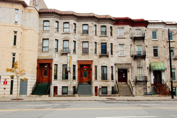 A row of historic brownstone buildings with multiple windows and doors, some with fire escapes. - Casa Bella Hotel (Montreal)