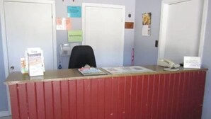 A reception desk with a red finish, a telephone, and a bulletin board with notes. - Skyways Motel Muskoka Gravenhurst ON 11 (Gravenhurst)