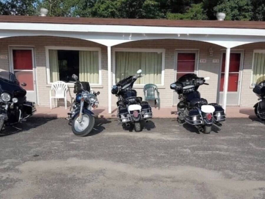 A motel with five motorcycles parked in front.