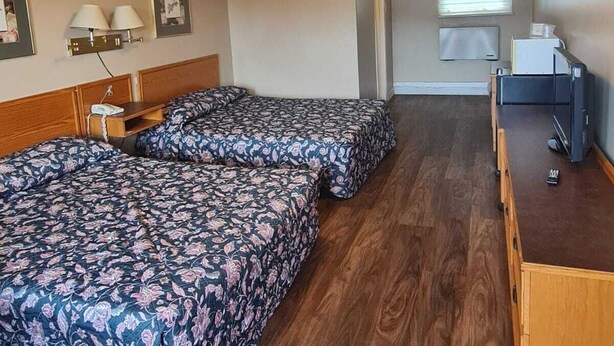A room with two beds, a desk, a chair, a window with blinds, and a ceiling light. - Skyways Motel Muskoka Gravenhurst ON 11 (Gravenhurst)