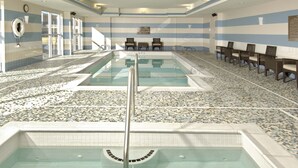 An indoor swimming pool with two lanes, tiled walls, and a seating area with chairs. - Hilton Garden Inn Portsmouth Downtown (Portsmouth)