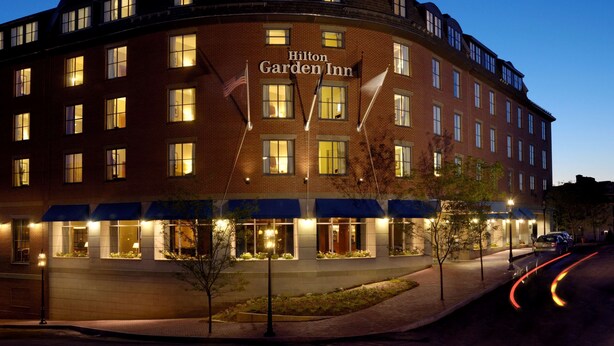 A Hilton Garden Inn hotel with multiple stories, large windows, and a well-lit facade. - Hilton Garden Inn Portsmouth Downtown (Portsmouth)