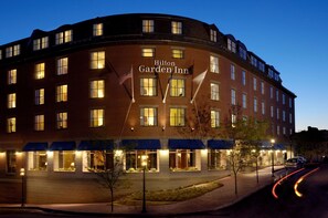 Un hôtel Hilton Garden Inn à plusieurs étages, doté de grandes fenêtres et d’une façade bien éclairée.