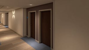 Un corridoio con porte in legno e pavimento rivestito di moquette.