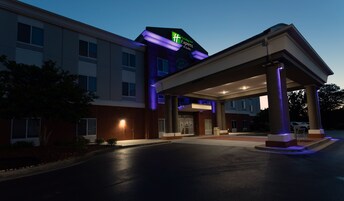 Edificio de Holiday Inn Express & Suites con entrada cubierta y un cartel que indica el nombre.