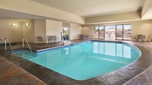 An indoor swimming pool with clear blue water, surrounded by a tiled deck and a few chairs. - Hampton Inn & Suites Lawton (Lawton)