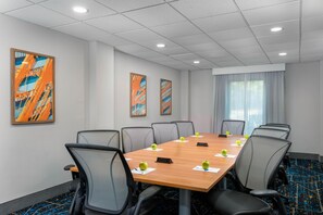 A conference room with a long table, chairs, and artwork on the walls. - Hampton Inn South Plainfield-Piscataway (South Plainfield)