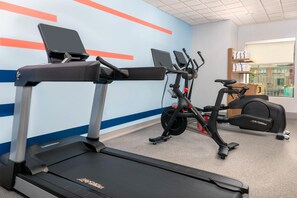 A gym with treadmills, stationary bikes, and a rowing machine.