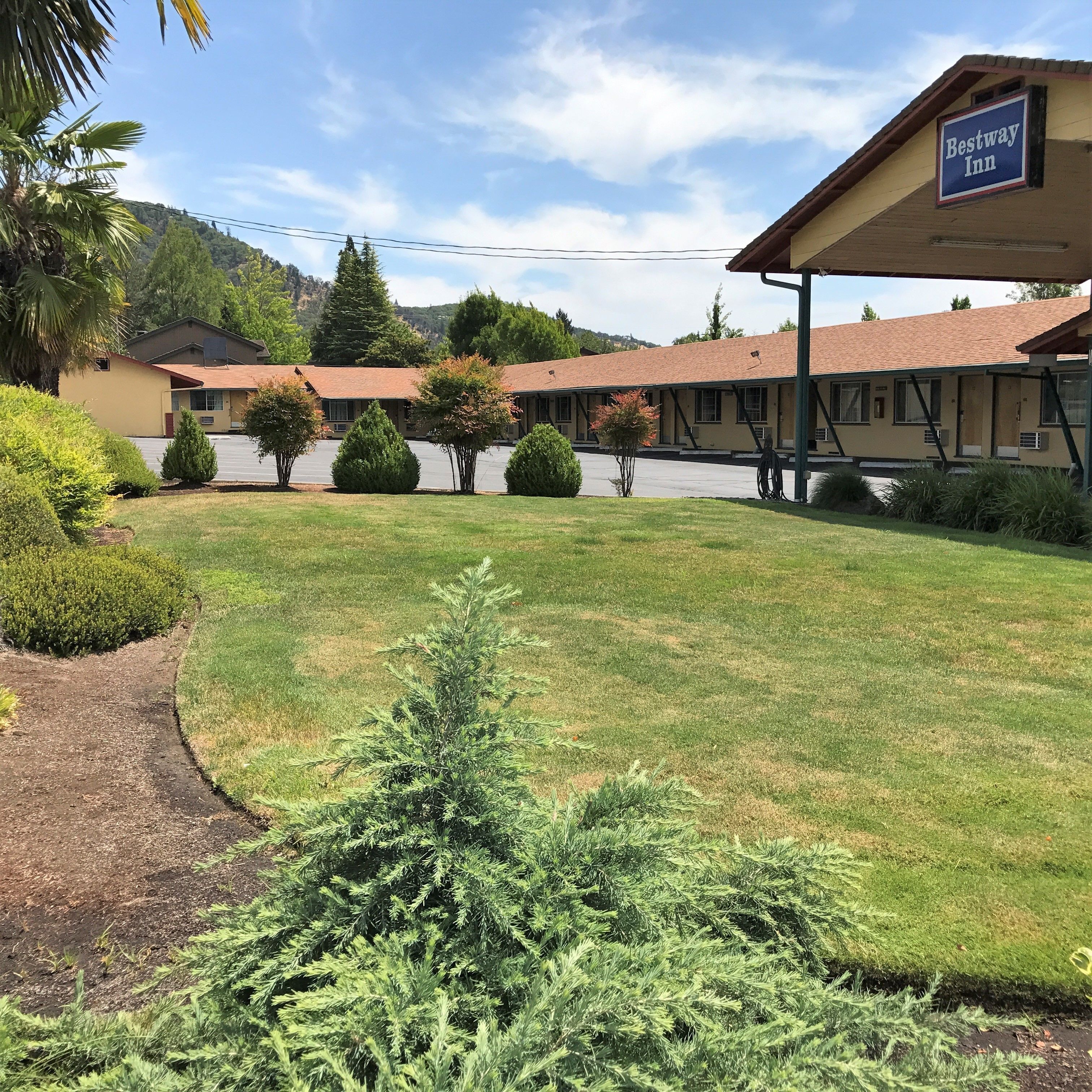 A Bestway Inn with a covered outdoor area, a parking lot, and a well-maintained lawn.