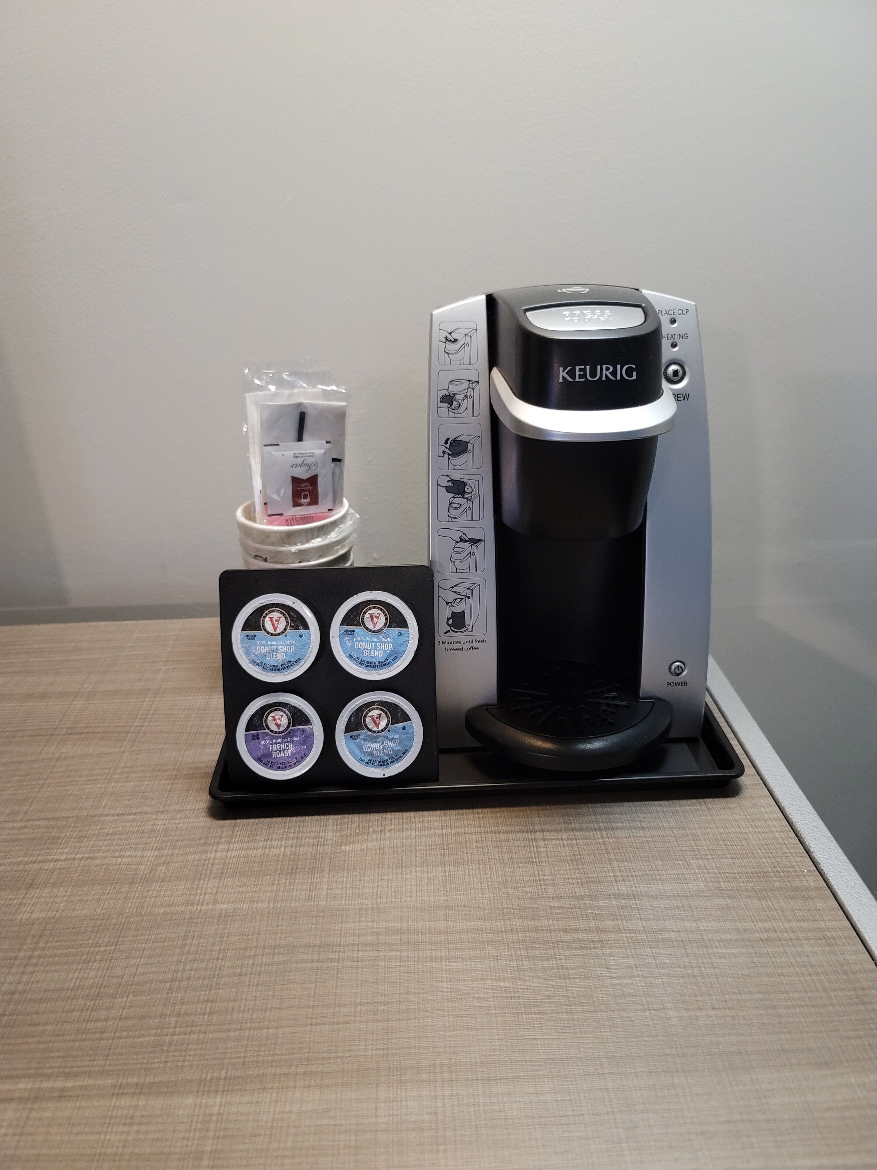 Eine Keurig-Kaffeemaschine mit Pod-Halter und sechs Kaffeekapseln.