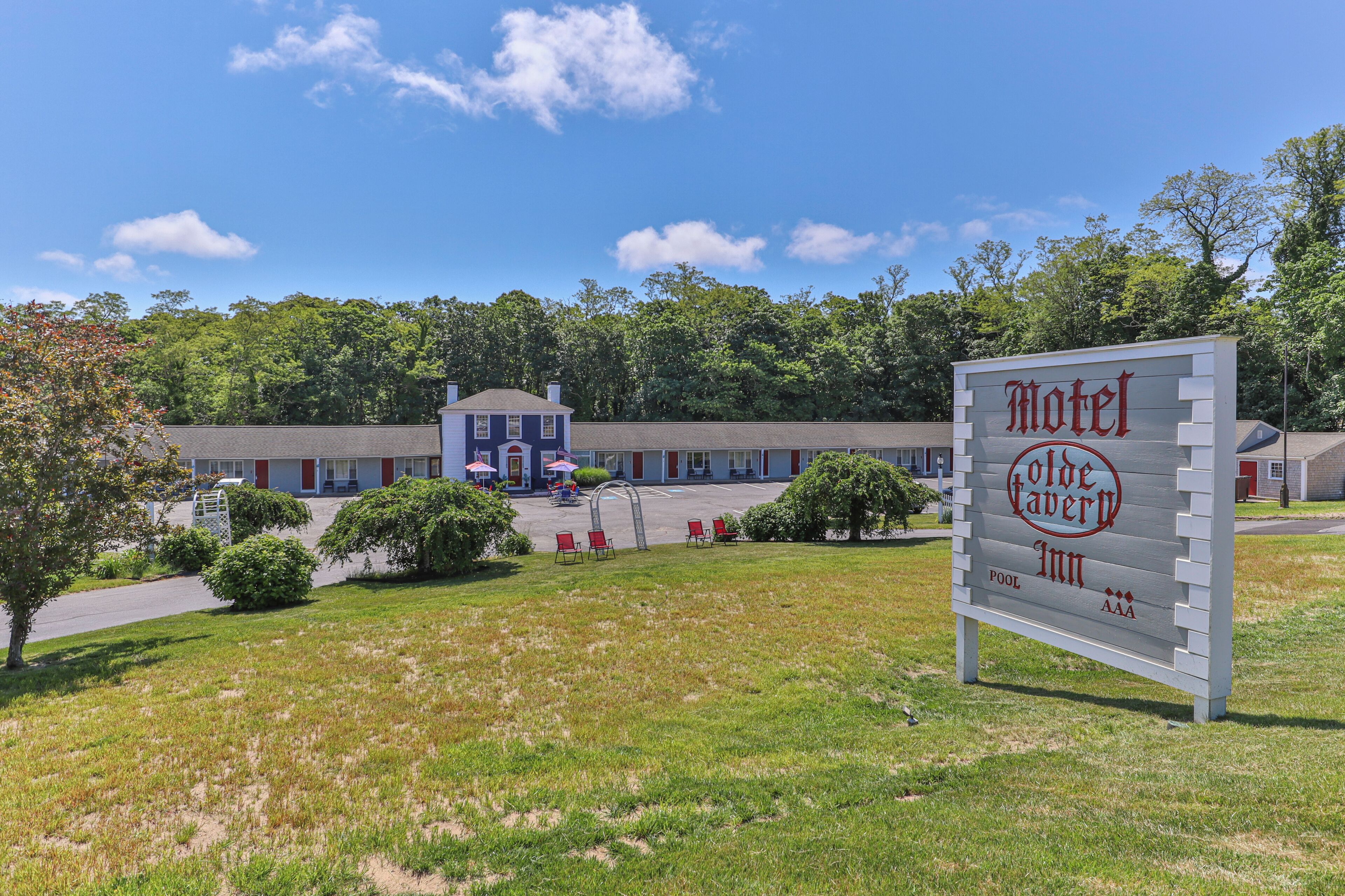 Une enseigne de motel avec une piscine et un bâtiment en arrière-plan.