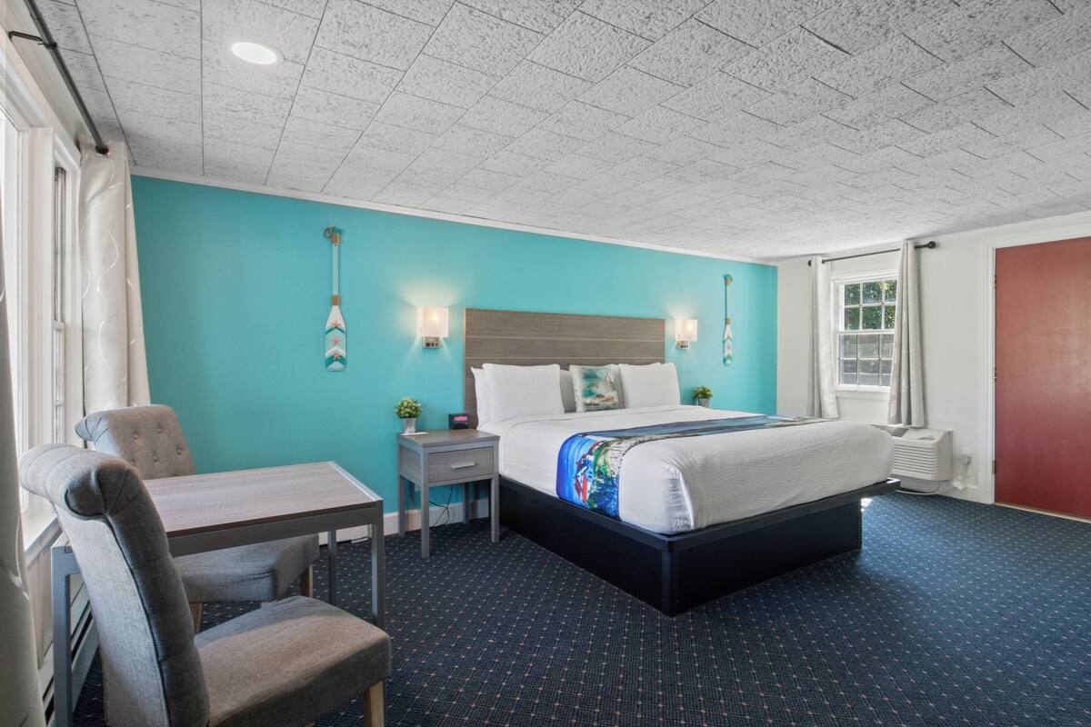A hotel room with a bed, a desk, and a chair.