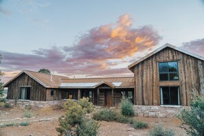 Un edificio rústico de madera con base de piedra, ventanas grandes y techo de metal.