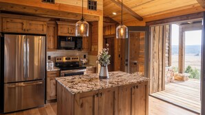 Una cocina con armarios de madera, electrodomésticos de acero inoxidable y encimera de granito.