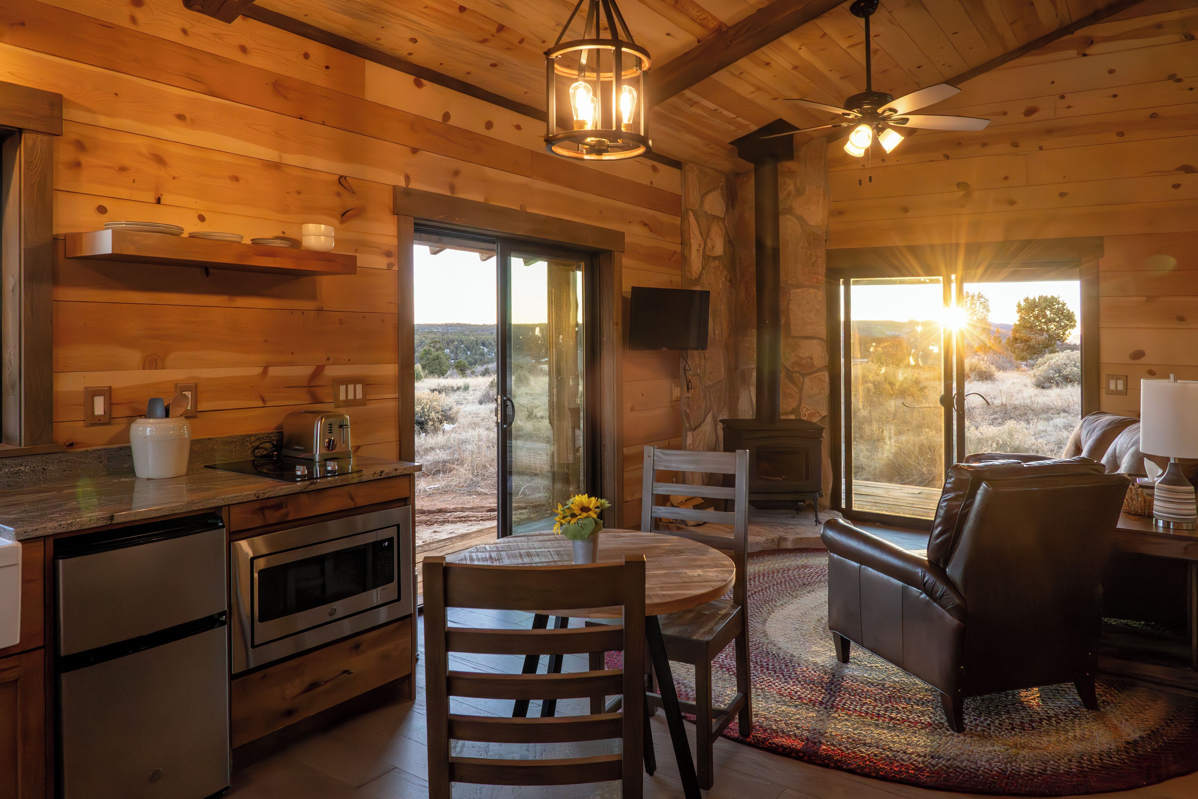 Un intérieur en bois comprenant un coin repas, une cuisine et une cheminée.