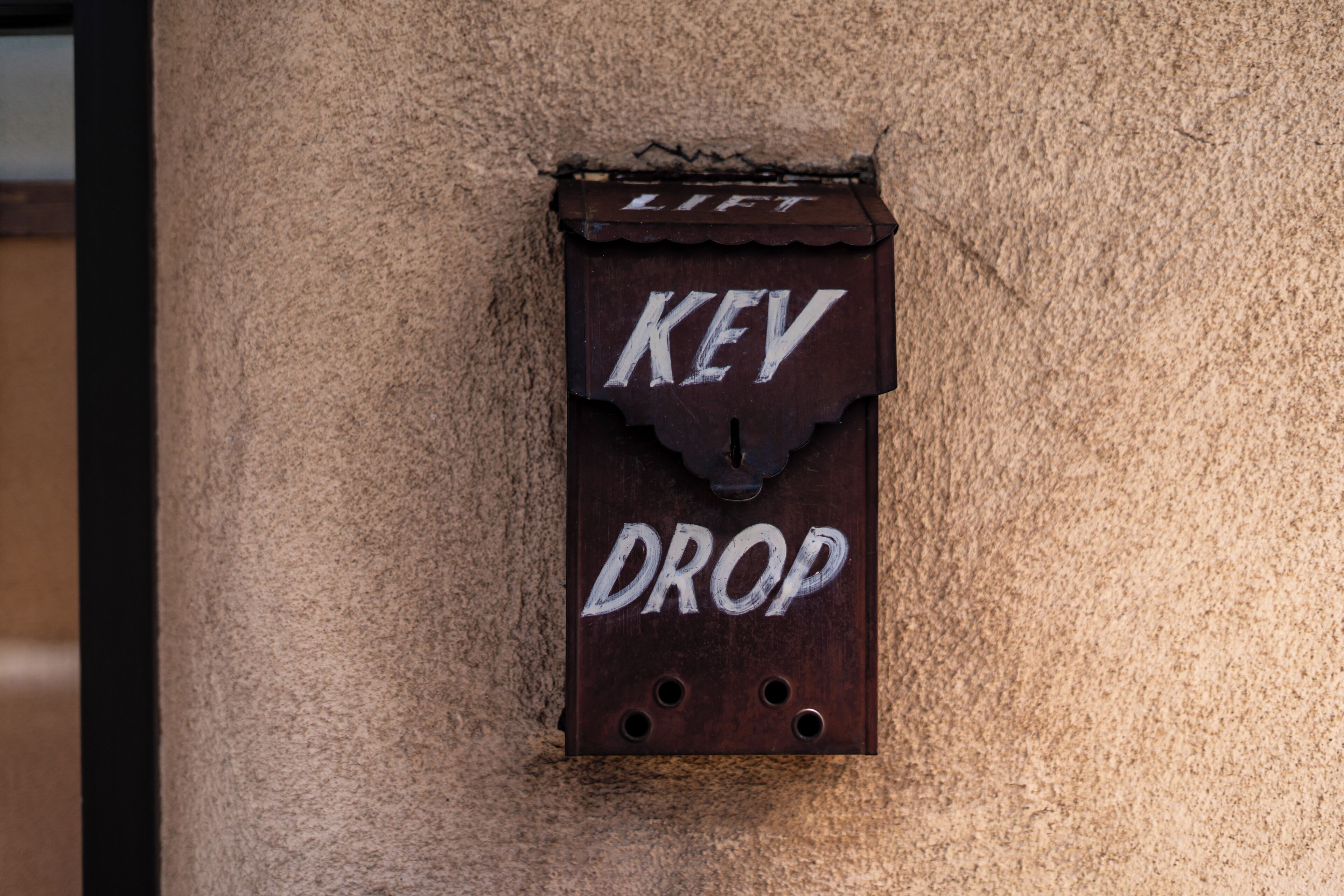 Un buzón de metal con las palabras "LIFT KEV DROP".
