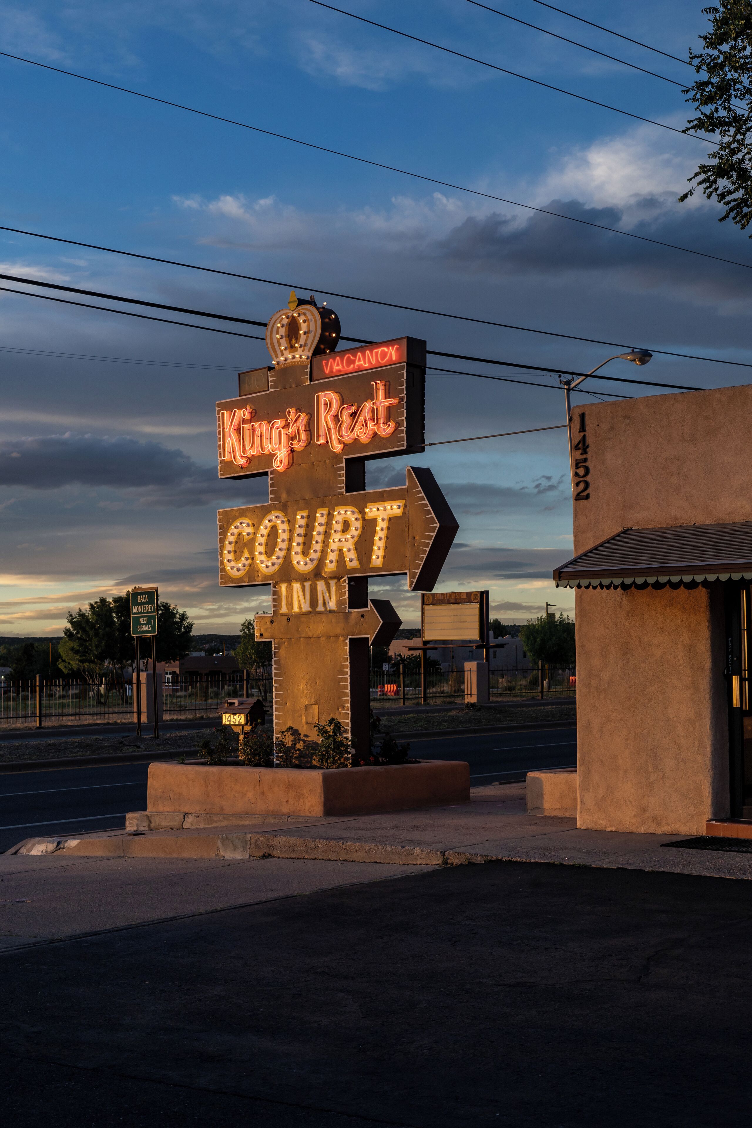 Une enseigne au néon indiquant « King's Rest Court Inn » et comportant des flèches directionnelles.