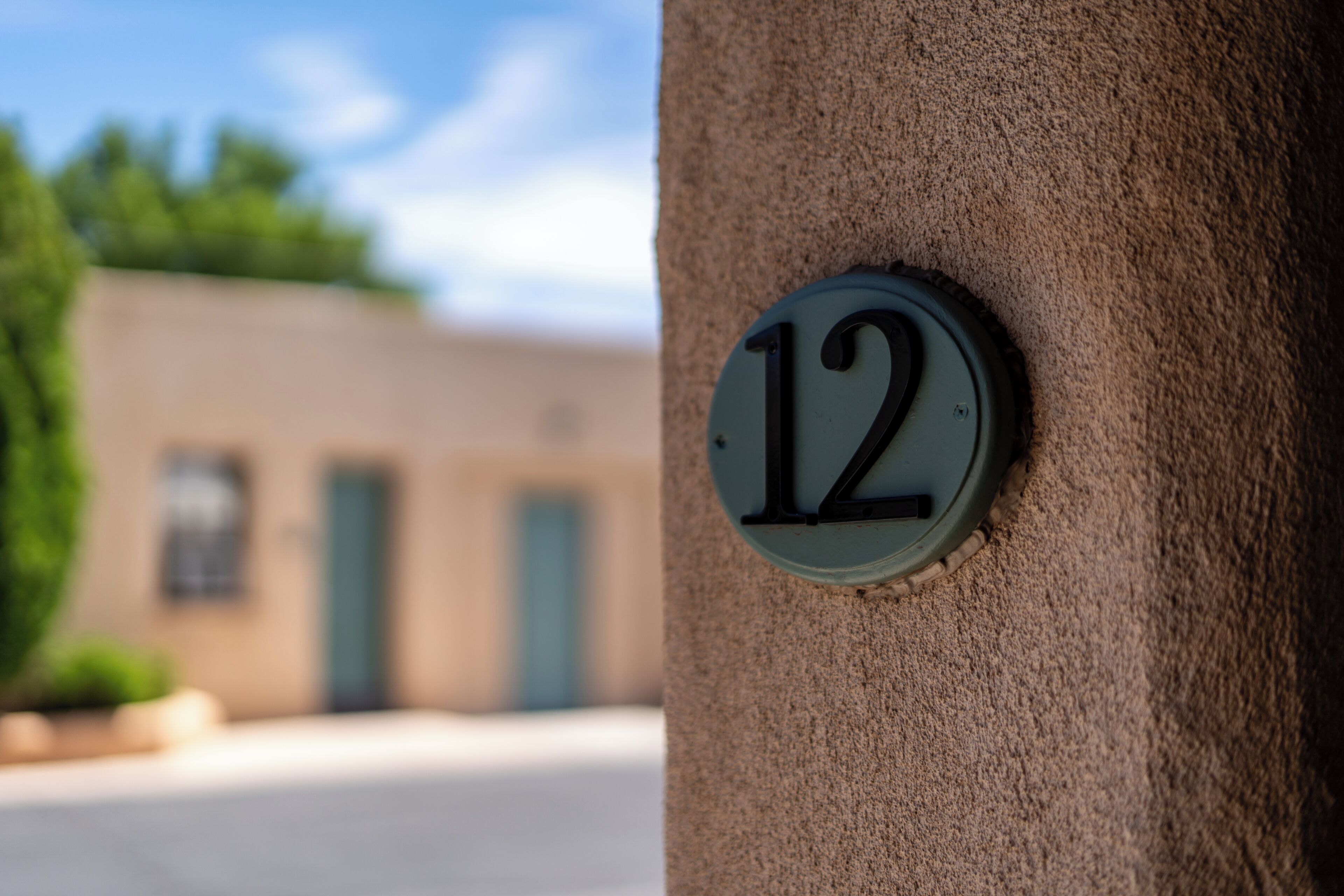A house number '12' on a textured wall.