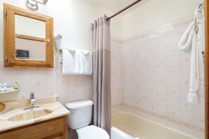A bathroom with a sink, toilet, and bathtub.