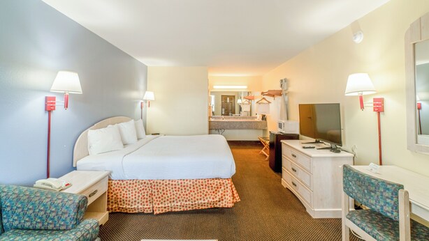 A hotel room with a bed, desk, chair, and a television. - Shale Inn Andrews (Andrews)