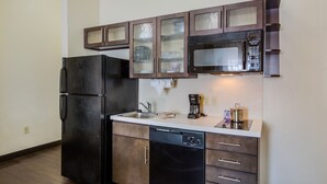 A compact kitchen with a refrigerator, microwave, and dishwasher. - Candlewood Suites Virginia Beach Town Center by IHG (Virginia Beach)