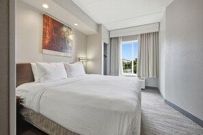 A hotel room with a large bed, a painting on the wall, a window with curtains, and a ceiling light. - SpringHill Suites by Marriott Arundel Mills BWI Airport (Hanover)