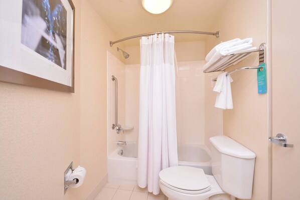 Un baño con inodoro, bañera, ducha y un perchero para toallas.